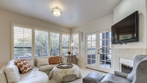 A spacious living room with a fireplace, large windows, and a cozy seating area.