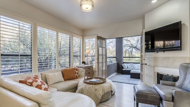 A spacious living area with a fireplace, large windows, and a comfortable seating arrangement.