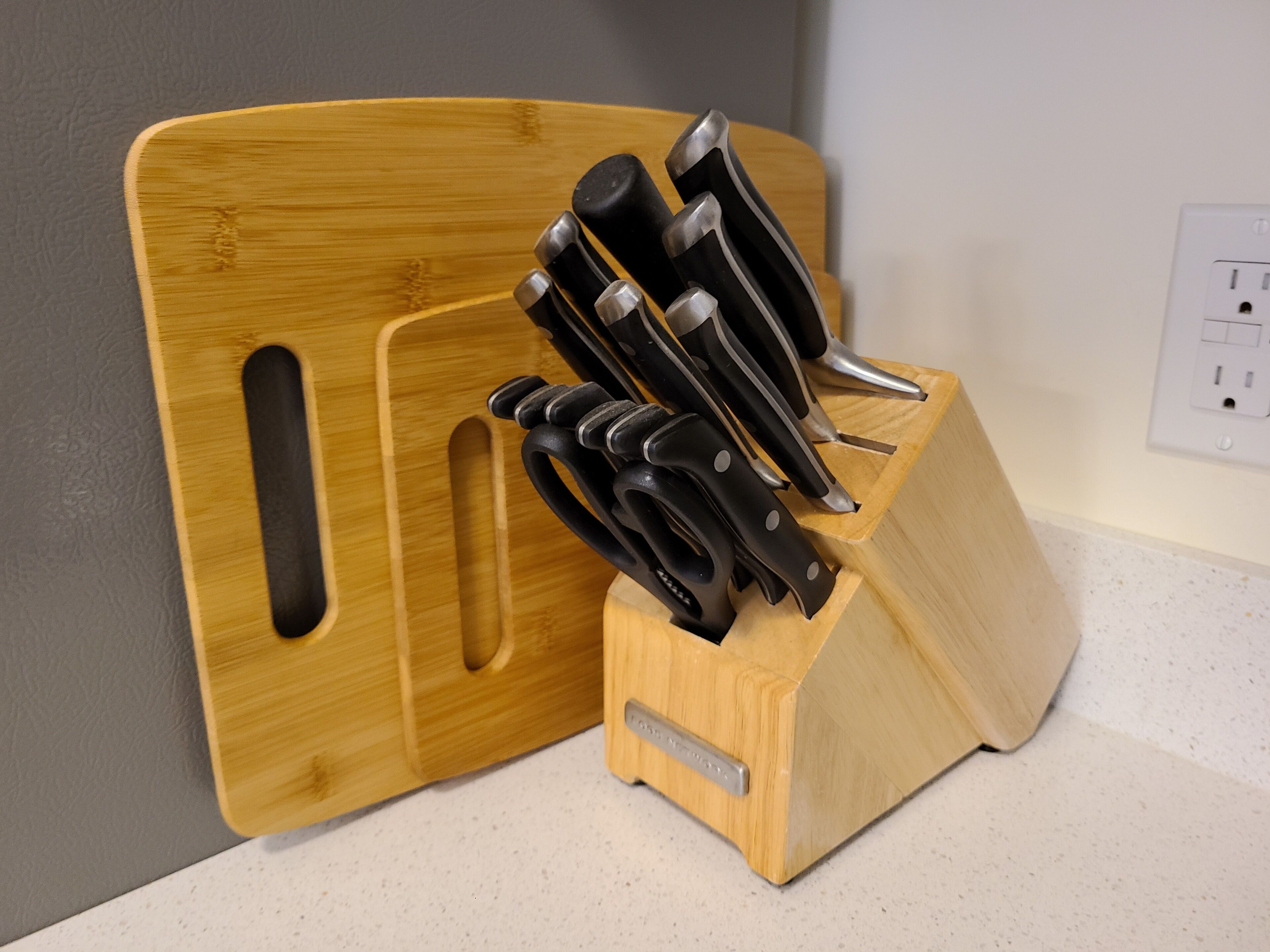 A wooden knife block with several knives on a countertop.