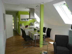 A modern kitchen with a dining area, a small table, and chairs. - Die Wohlfühloase, Deutschland (Frankenau)