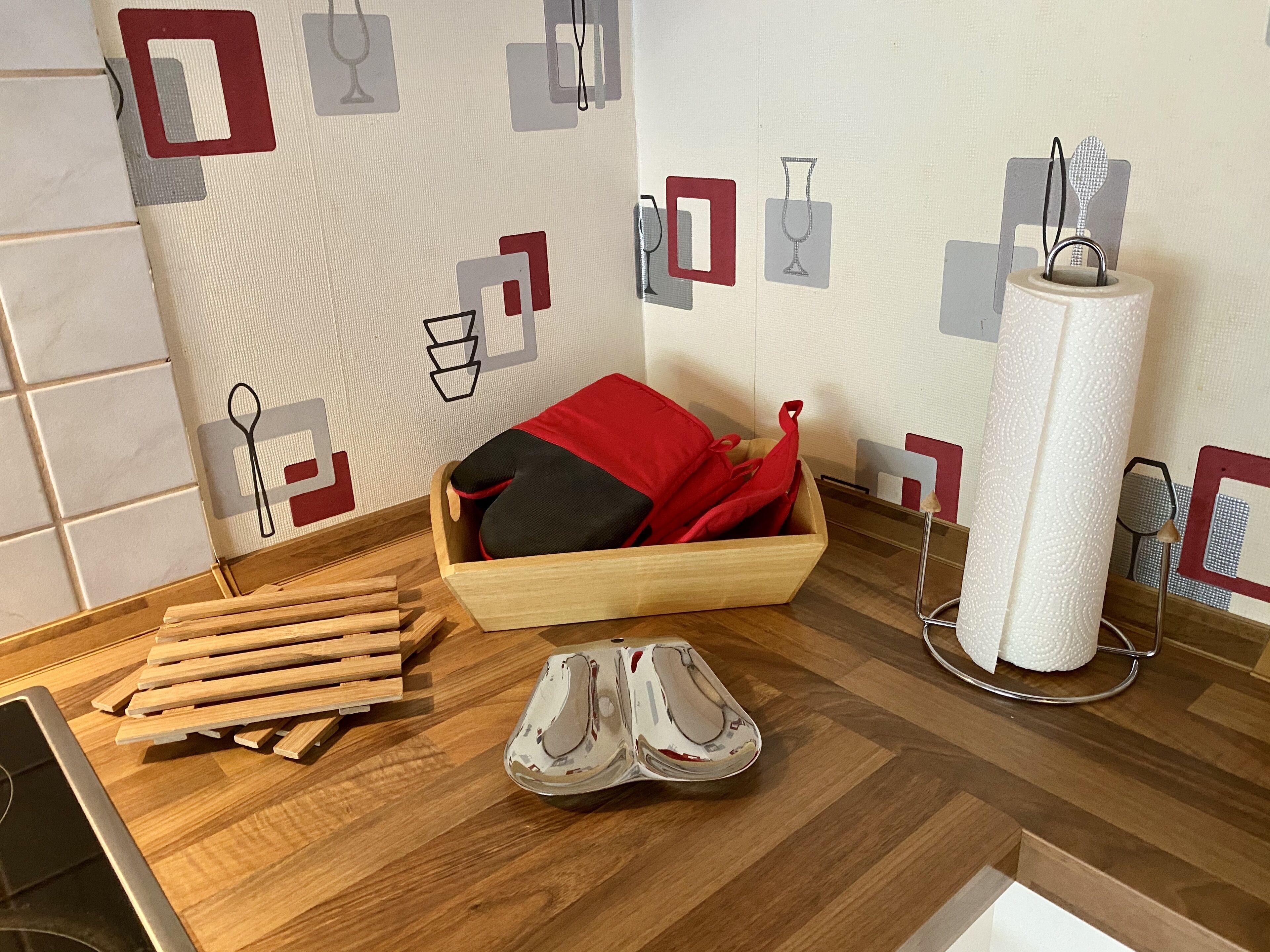 Une table en bois, un coussin rouge, une paire de chaussures et un rouleau de papier mouchoir.