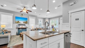 A modern kitchen with white cabinetry, a granite countertop, and a built-in dishwasher. - 🐙Golf Cart + Bikes Included-Pools-2 Masters-Octopus's Garden🐙 (Santa Rosa Beach)