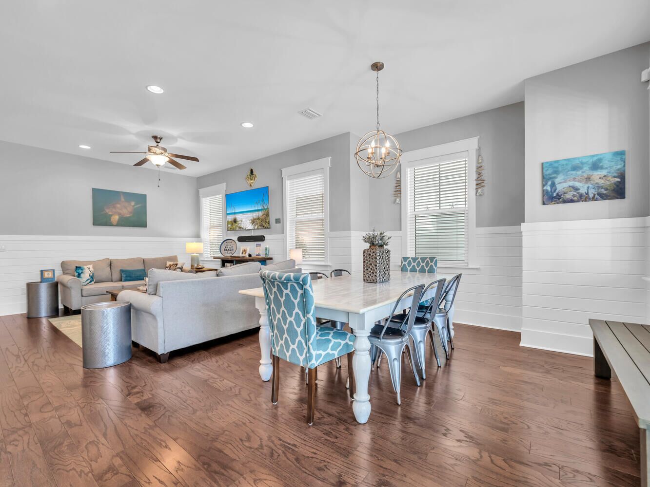 A spacious living area with a dining table, chairs, and a sofa.