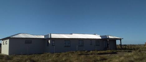 A single-story building with a metal roof and multiple windows.