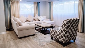 Ein modernes Wohnzimmer mit Sofa, Sessel und Couchtisch.