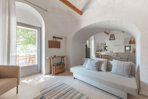Un salon moderne avec un canapé blanc, un tapis à rayures et une table en bois sur laquelle se trouve un panier.