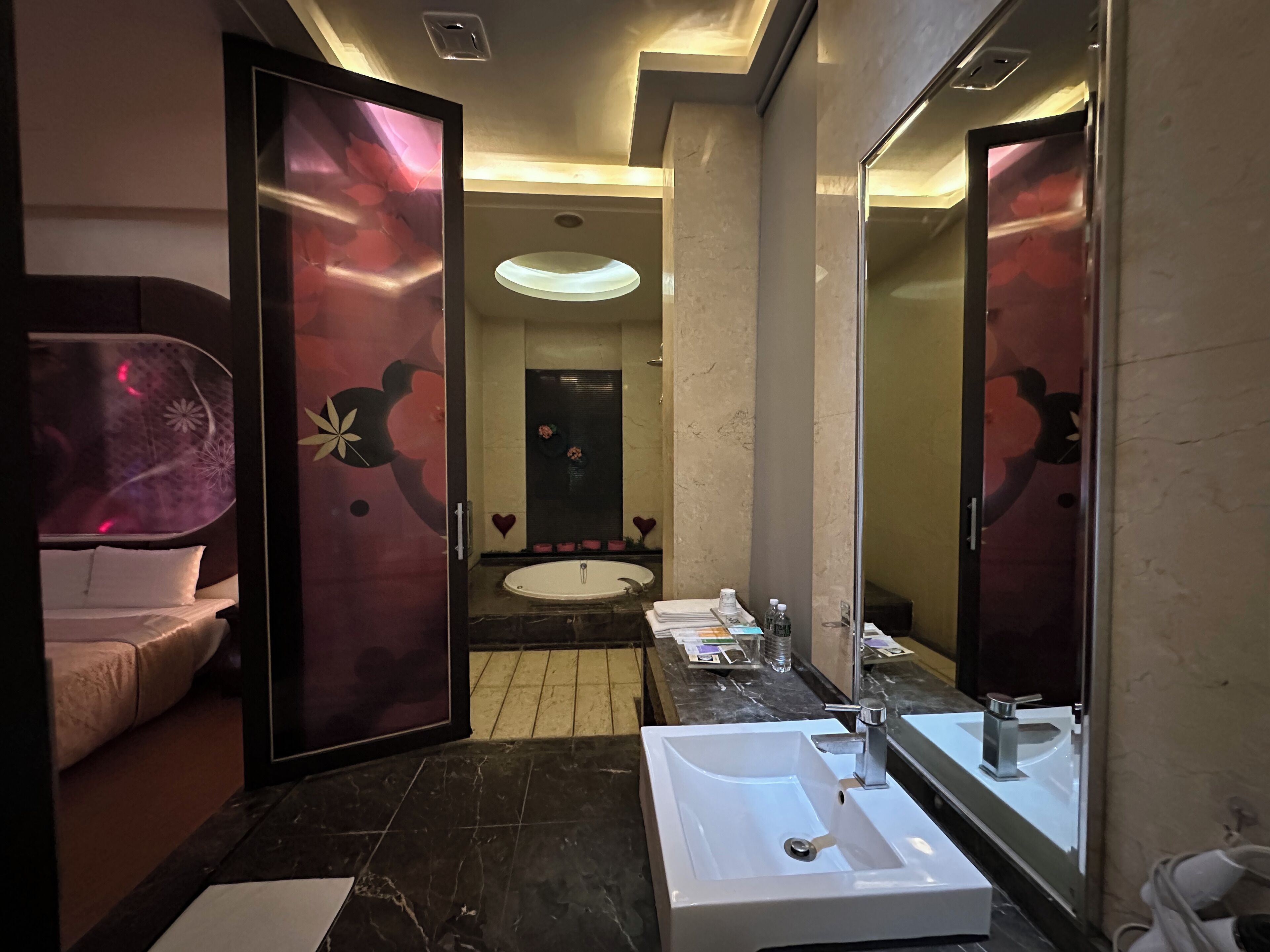 A modern bathroom with a large mirror, two sinks, and a vanity area.