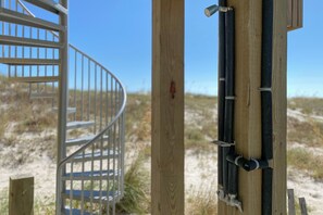 Eine Wendeltreppe führt zu einem Holzdeck mit Metallgeländer.