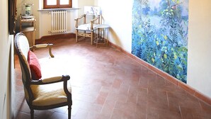 A room with a rustic wooden ceiling, a mural of a landscape, a radiator, and a chair with a cushion. - Chianti Tuscany: a villa with a view (Lucolena)
