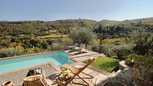 A pool area with lounge chairs and a view of a hilly landscape. - Chianti Tuscany: a villa with a view (Lucolena)