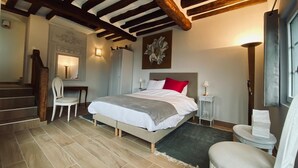 A bedroom with a bed, a desk, a chair, a wardrobe, and a staircase. - Impressionist artist's house on the GR2 (La Roche-Guyon)