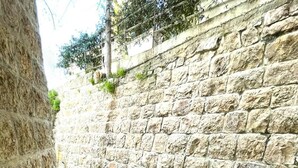 A stone-walled corridor with steps leading to a higher level. - Broummana House (Broumana)