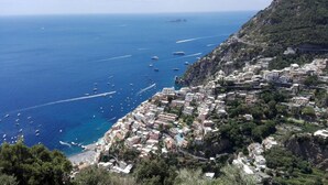 A coastal town with buildings along the cliffside, a beach, and boats in the water. - CASA INCANTO, beautiful house with stunning views and parking space (Positano)