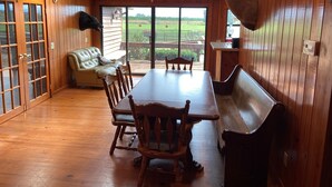 A wooden interior with a dining table, chairs, a leather sofa, and a mounted deer head. - Former Hunting Lodge on 24 Acres with Lake with heated pool (Spring Hill)
