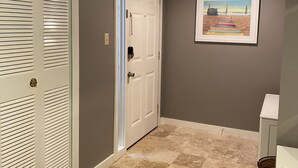 A hallway with a white door, a framed picture on the wall, and a wooden floor. - 3 Min Walk to Beach & Marina-Free Bikes/Pool/Tennis (Hilton Head Island)