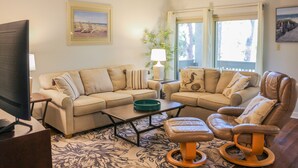 A living room with a beige sofa, a brown leather chair, a coffee table, and a television. - 3 Min Walk to Beach & Marina-Free Bikes/Pool/Tennis (Hilton Head Island)