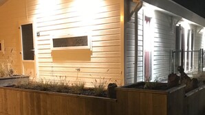 Ein modernes Haus mit Holzfassade, einer Veranda und einem gut beleuchteten Eingang.