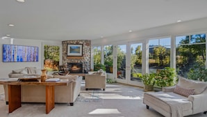 A spacious living room with a fireplace, comfortable seating, and large windows offering a view of the outdoors. - River Frontage! Family Friendly Mtn Retreat (Glenwood Springs)