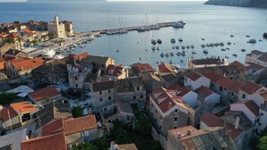 Une ville côtière dotée de bâtiments historiques, d’un port de plaisance et d’une tour imposante.