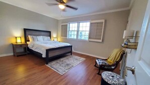 A bedroom with a bed, bedside lamps, a ceiling fan, a window with blinds, a chair, and a small ottoman. - Townhome in gated community nearby a lot of attraction shopping and restaurants  (Sandy Springs)