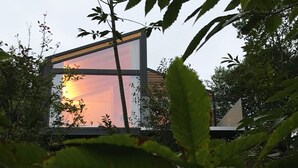 Un edificio moderno con grandes ventanales que reflejan el atardecer.