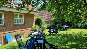 A brick house with a patio area featuring outdoor furniture. - Three-room apartment with 2 bathrooms for up to 8 people. (Kellenhusen)