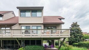 Una casa de dos pisos con un balcón y un patio cubierto.