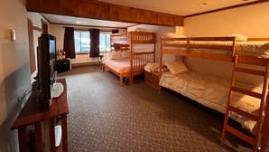 A bunk bed room with a desk, television, and a window with curtains. - Cozy Killington Mountain View Condo (Killington)