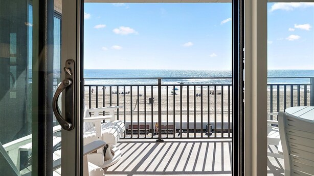 Un balcon avec vue sur une plage et l’océan.