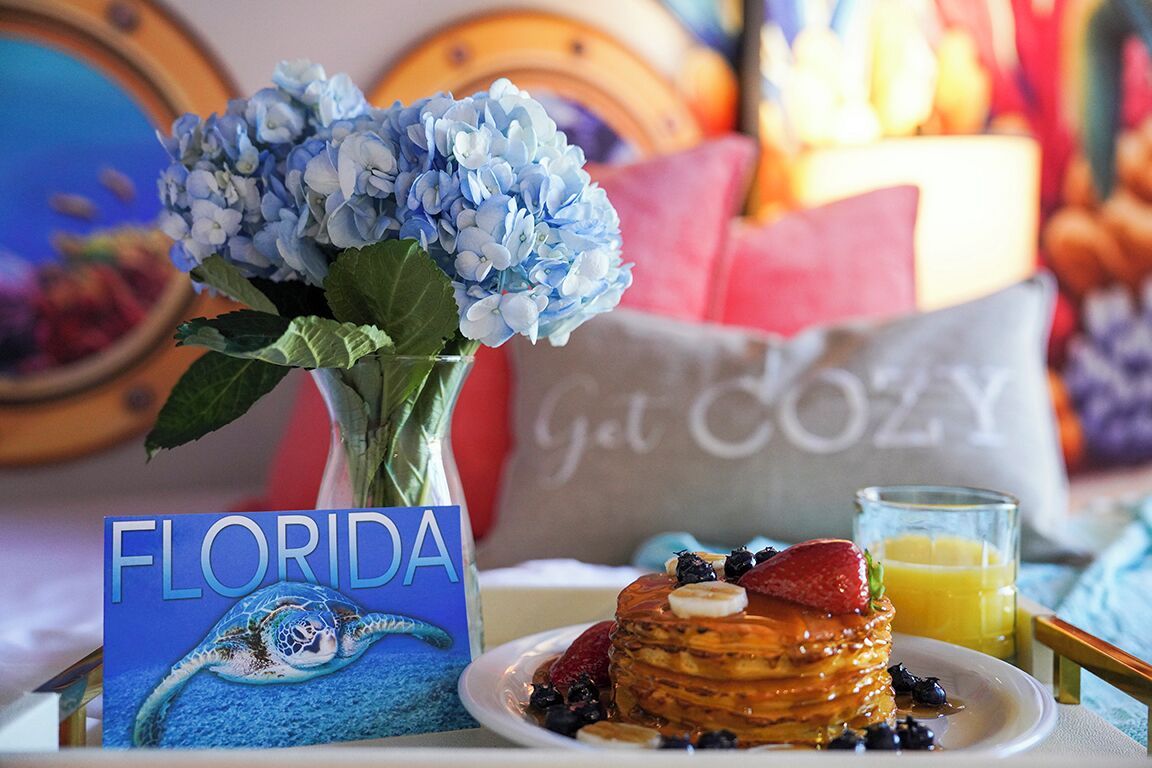 Desayuno con tortitas, frutos rojos y una tarjeta con motivos de Florida.