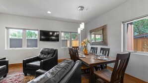 A dining area with a wooden table, black leather chairs, and a sofa. - 57 Robber`s Roost #2 - Frontier (ADA accessible!) (Moab)