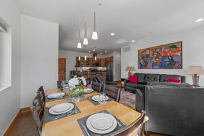 Enjoy a meal at the dining table, surrounded by a comfortable seating area and a vibrant abstract painting.