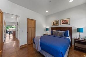 Relax in this inviting room with a large bed, two bedside tables, and a balcony view.