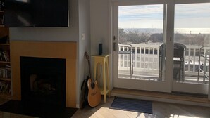 A living room with a fireplace, a television, and a sign reading "Beach House". - Oceanfront 3BR/3BA with direct ocean views, private parking and bikes included (Cape May)