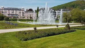 A fountain in a park with a building in the background. - Ferienwohnung Maria - Bad Kissingen (Bad Kissingen)