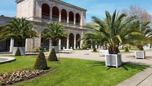 A building with a classical architectural style, featuring a central courtyard with palm trees and a fountain. - Ferienwohnung Maria - Bad Kissingen (Bad Kissingen)