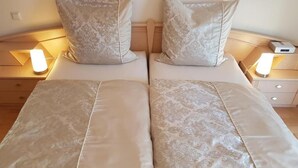 A double bed with matching pillows and bedside lamps. - Ferienwohnung Maria - Bad Kissingen (Bad Kissingen)