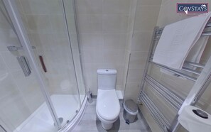 Een moderne badkamer met een douchecabine van glas, een toilet en een handdoekrek.