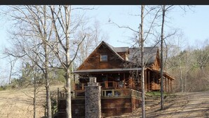 A rustic cabin with a stone foundation, wooden exterior, and a porch. - Remote Cabin with all amenities  (Lutts)