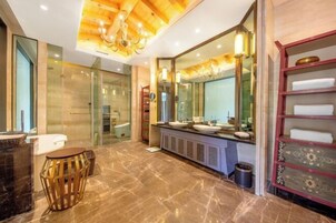 Un baño moderno con un espejo grande, dos lavamanos, un mueble de tocador y una zona de ducha.