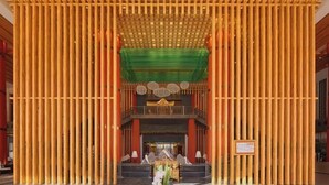 A traditional architectural interior with a central elevated platform, wooden columns, and a green canopy. - Evergrande Hotel, Nyingchi (Nyingchi)