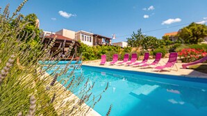 A swimming pool with pink lounge chairs and a building in the background. - Stunning home in Rogoznica (Rogoznica)