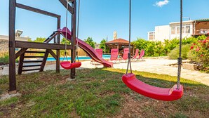 A playground with swings and a slide, a pool, and a gazebo in a backyard. - Stunning home in Rogoznica (Rogoznica)