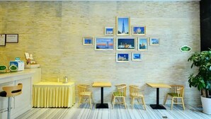 A restaurant with a stone wall, framed pictures, and wooden furniture. - Vienna Apartment (Shenzhen)
