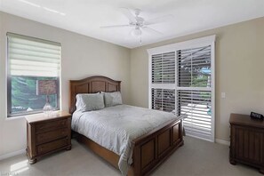 A bedroom with a bed, a nightstand, a dresser, a ceiling fan, and a window with blinds. - Serene Waterfront Home, walk to TigerTail Beach, Pet Friendly, EV Charger (Marco Island)