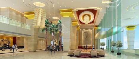A spacious lobby with a high ceiling, modern lighting fixtures, and a central seating area.