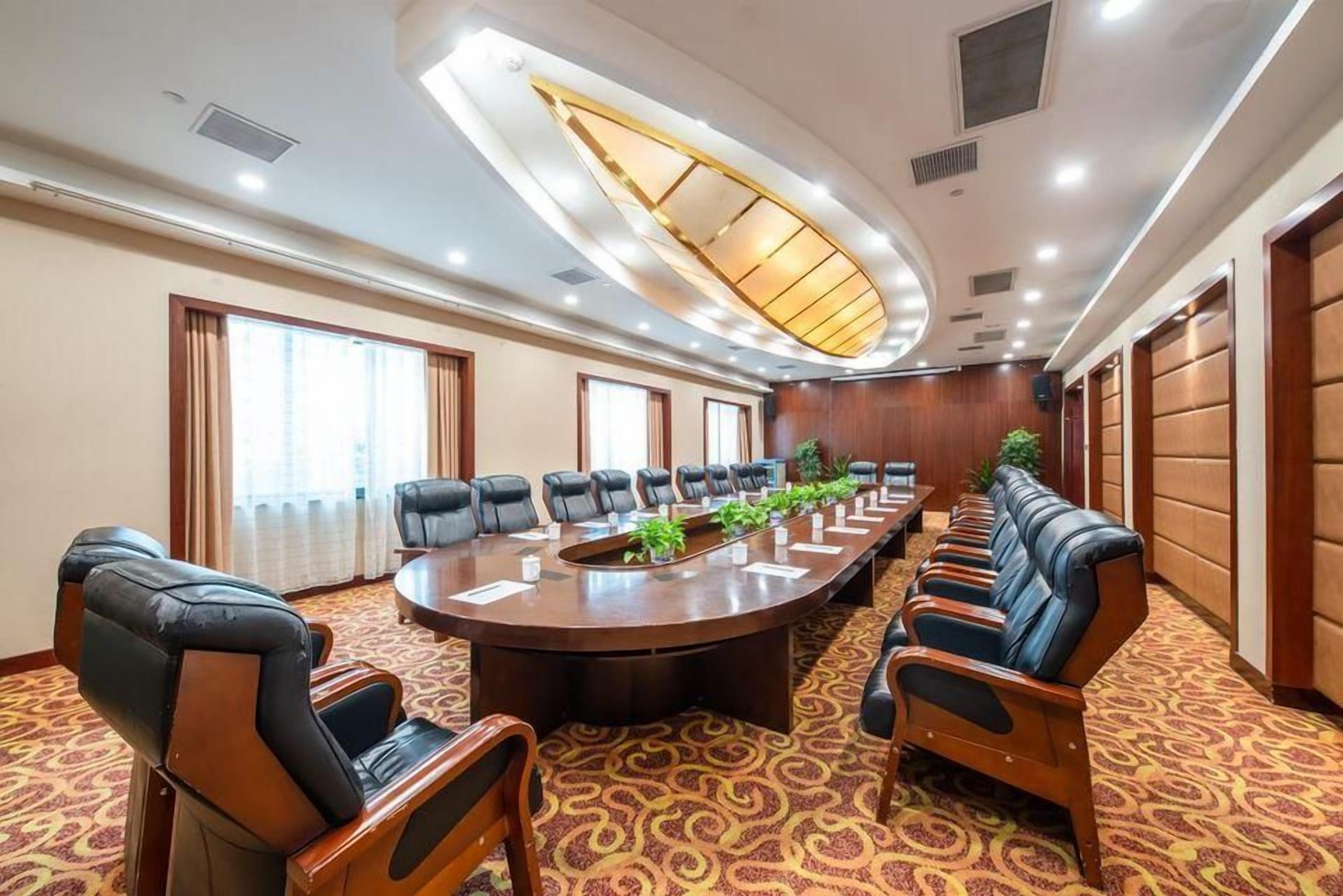 Un salón de conferencias con una larga mesa, sillas y un diseño de techo original.