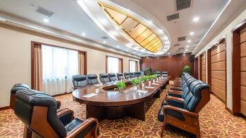 Un salón de conferencias con una larga mesa, sillas y un diseño de techo original.