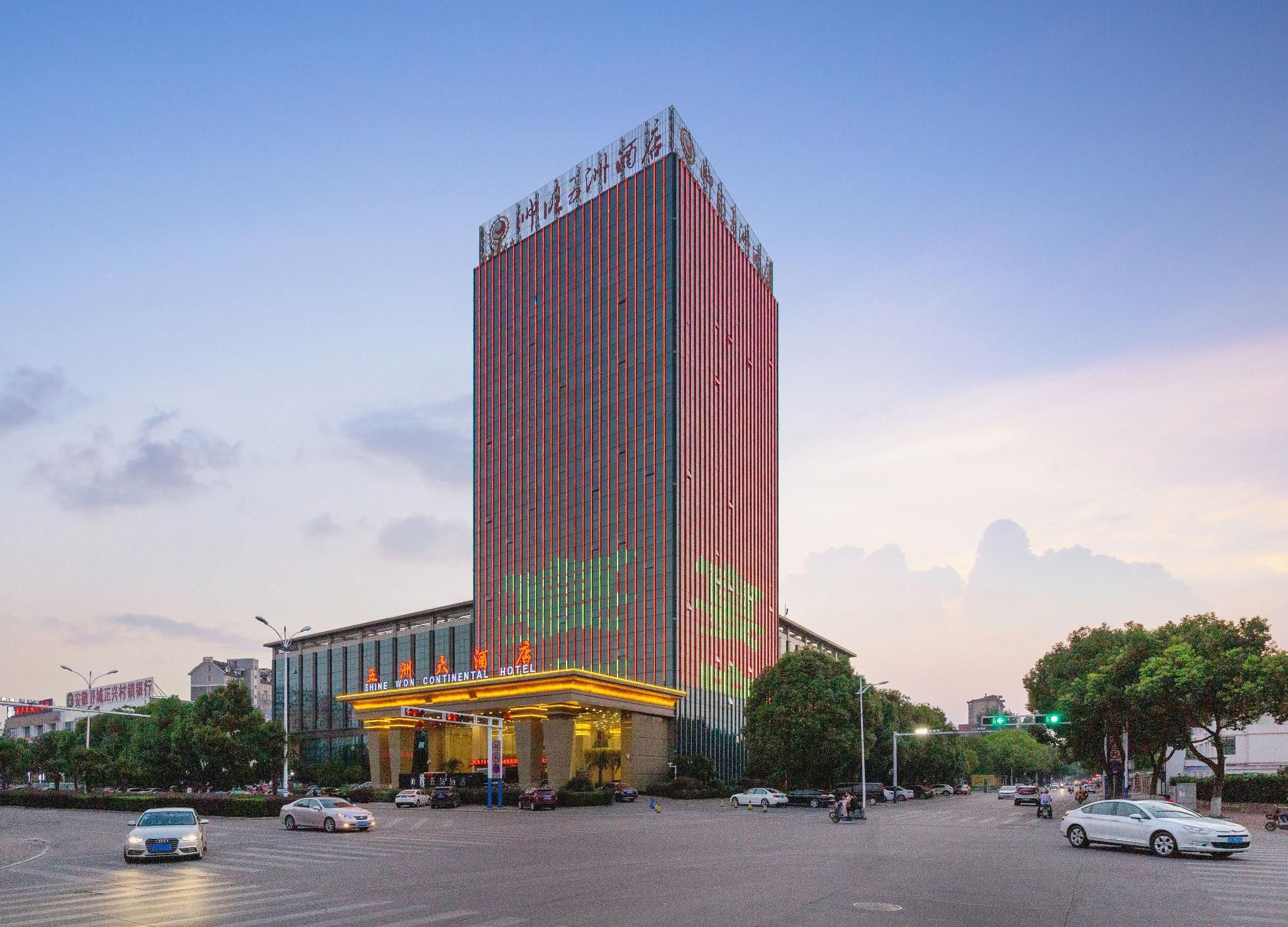 A tall hotel with a modern design, featuring a prominent entrance with illuminated signage.