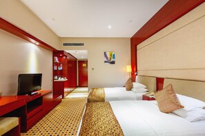 Una habitación de hotel con cama, televisión, escritorio y armario.
